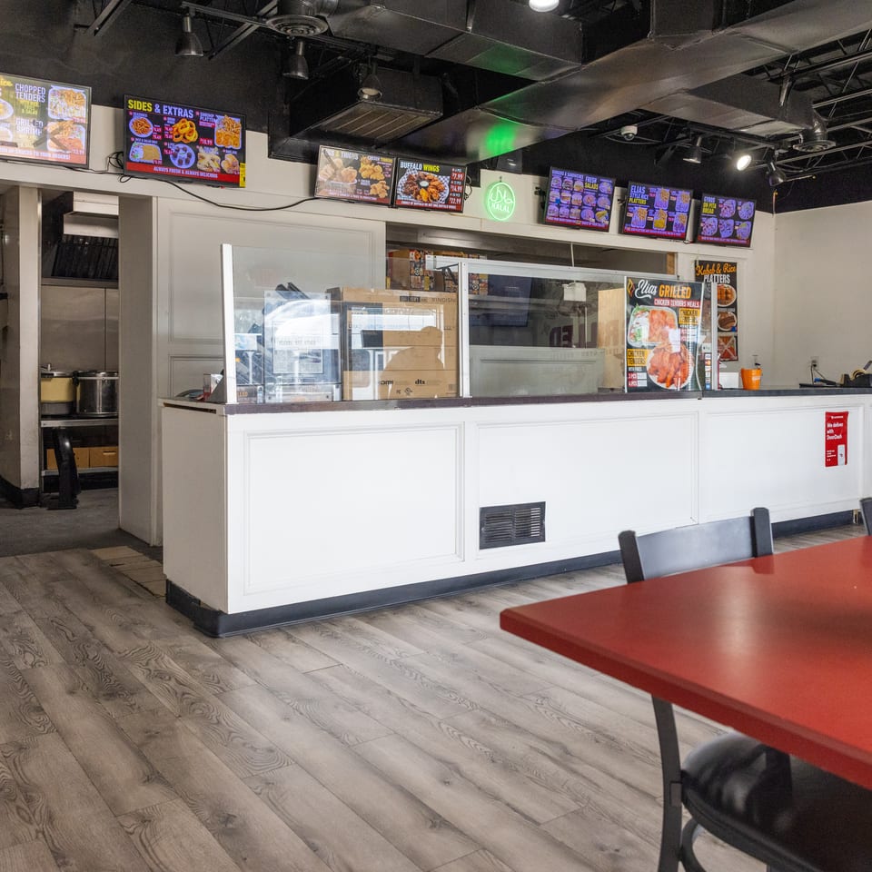 Halal restaurant counter with digital menus featuring kebabs, rice platters, chicken tenders, wings, gyros, and sandwiches.